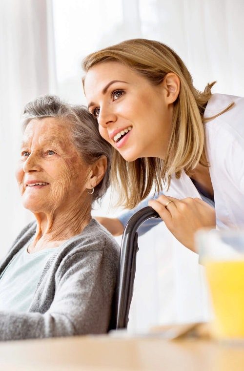 Foto Pflegekraft und ältere Frau lächelnd